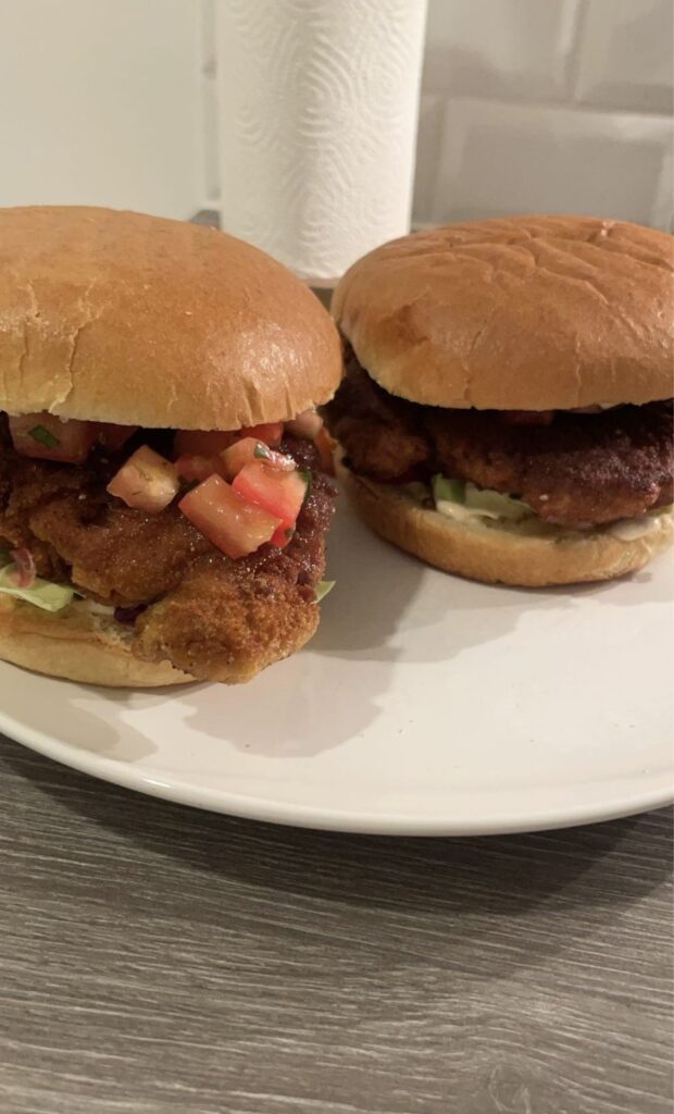 To burgere med paneret fasanbryst, salat og tomat