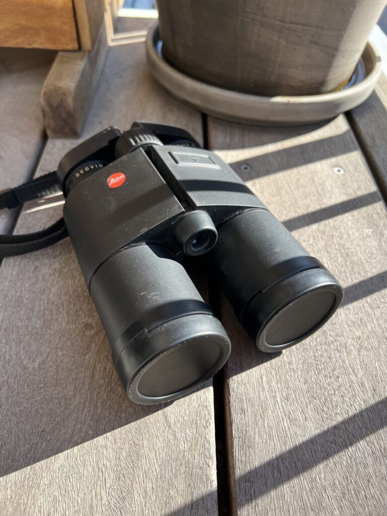 Leica Geovid 8x42 R liggende med beskyttelsescovers på objektiverne