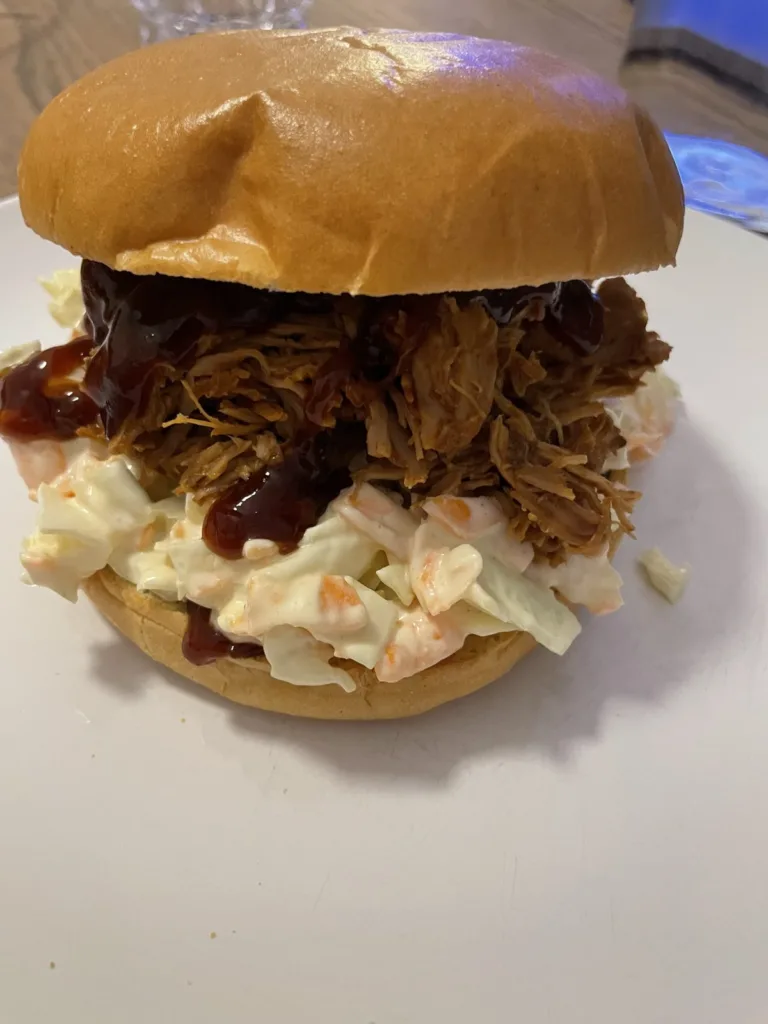 Burger med pulled fasan, BBQ-sauce og coleslaw i en blød burgerbolle